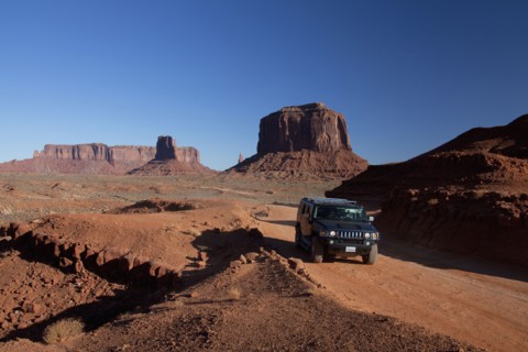 Car driving on remote road through rock formations