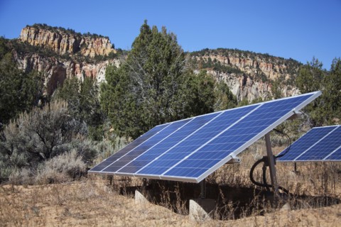 Solar panels in remote field near mountains
