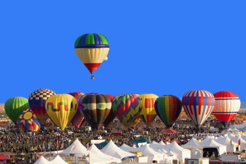 Hot air balloon floating above others at festival