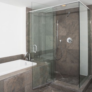 Glass doors of shower and bathtub in modern bathroom