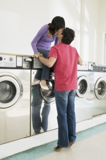 Asian couple kissing in laundromat