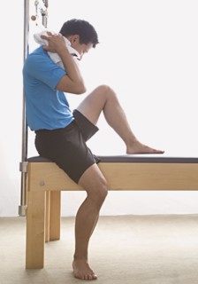 Asian man sitting on exercise equipment