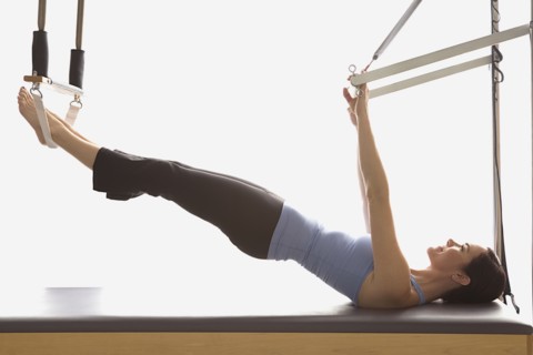 Woman stretching on exercise equipment