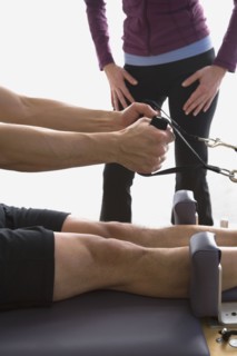 Asian man stretching on exercise equipment
