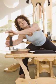 Senior woman stretching on exercise equipment