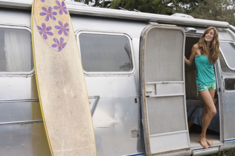 Mixed race woman standing in doorway of camper