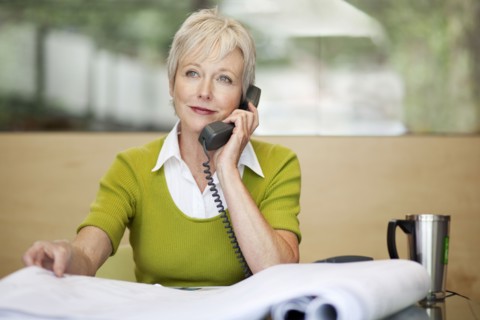 Smiling Caucasian architect talking on telephone