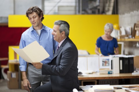 Businessmen reading file folder in office