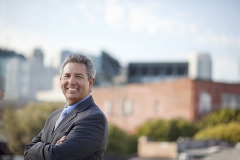 Portrait of smiling Hispanic businessman posing outdoors
