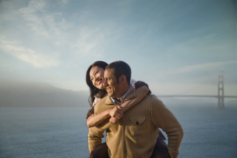 Man carrying woman piggyback near bay