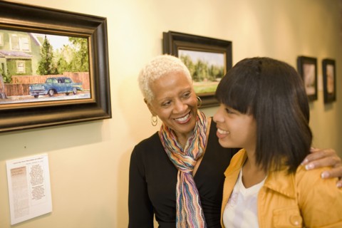 Grandmother and granddaughter hugging in gallery