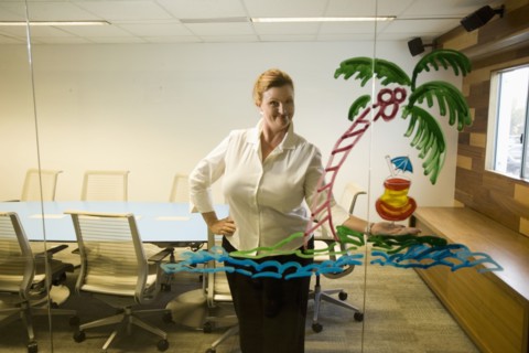 Caucasian businesswoman looking at drawing on conference room wall