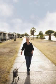 Senior Caucasian woman walking dog on sidewalk