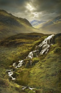 Creek flowing over rocks in rural landscape