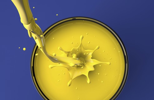 Yellow paint pouring into pot