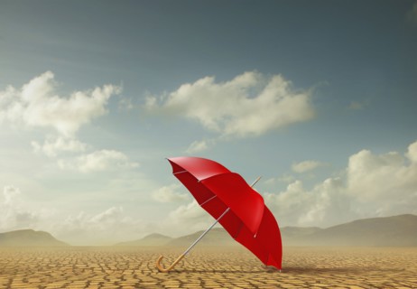Red umbrella in desert landscape