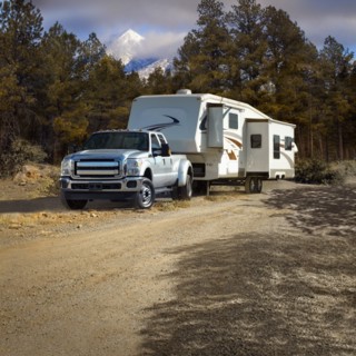 Truck pulling RV trailer on dirt road