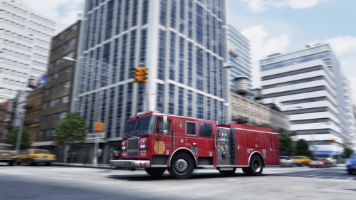 Blurred view of fire truck driving through intersection