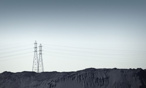 Silhouette of power lines over rocky landscape