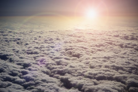 Sun shining in sky above clouds