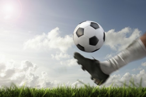 Blurred view of foot kicking soccer ball