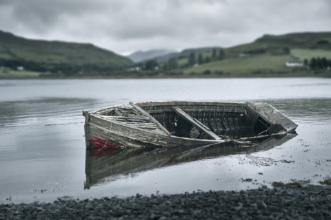 Dilapidated boat in rural lake