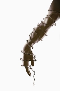 Arm and hand wrapped in barbed wire