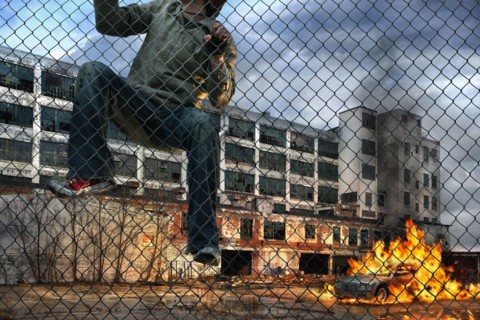 Man scaling wall in gritty urban neighborhood