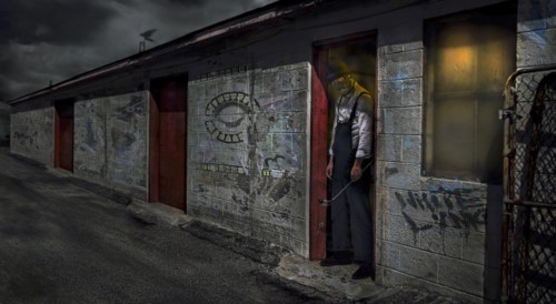 Man standing in dilapidated building doorway