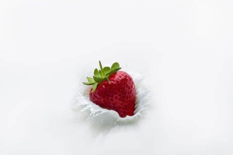 Strawberry splashing into milk