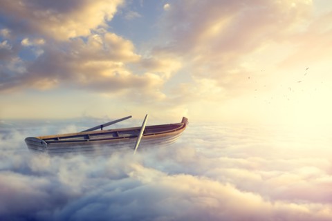 Empty rowboat above clouds