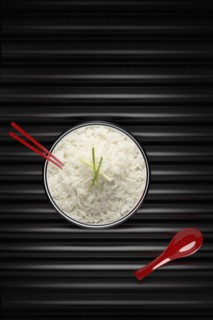 Chopsticks in bowl of white rice with red spoon