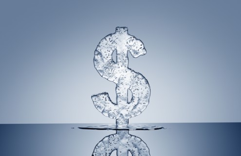 Puddle under melting ice dollar symbol