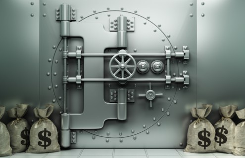 Money bags with dollar symbol on floor near vault
