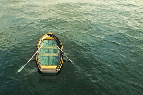 Abandoned sinking rowboat in ocean