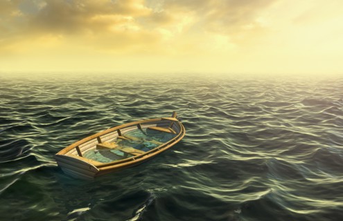 Abandoned sinking rowboat in ocean