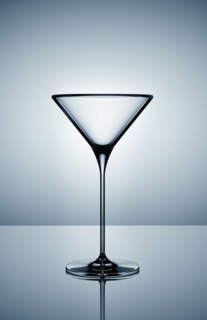 Empty martini glass on gray background