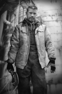 Serious Caucasian worker holding wrench on oil rig