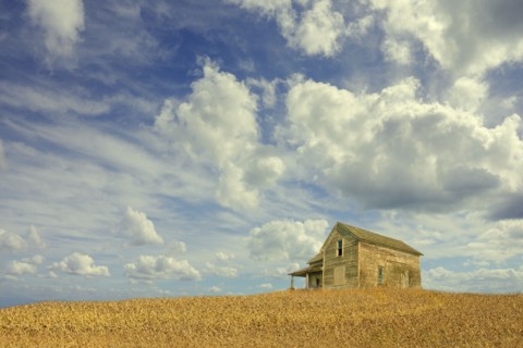 Clouds over remote wooden farmhouse