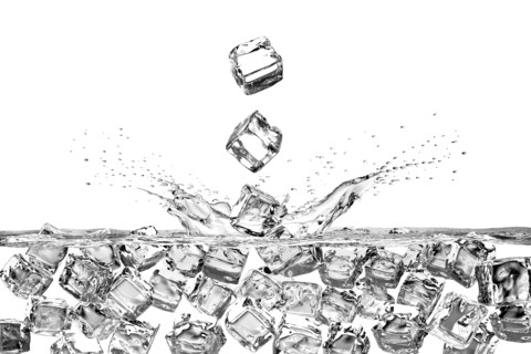 Falling ice cubes splashing into water and floating