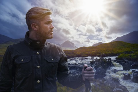 Caucasian hiker holding walking stick near river
