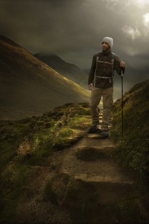 Caucasian hiker holding walking stick on mountain path