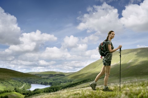 Caucasian woman hiking on green hill