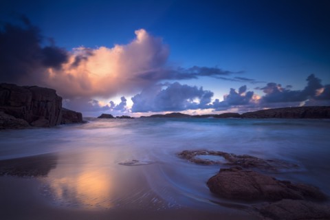 Calm waves on beach at sunset