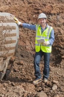 Hispanic construction worker standing in dirt