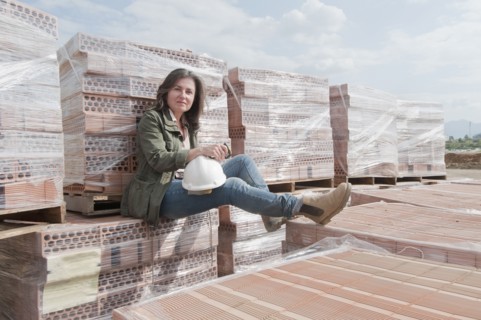 Caucasian construction worker sitting on stack of bricks
