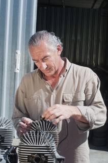 Hispanic mechanic working on engine