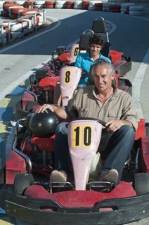 Hispanic grandfather and grandson on go-cart track
