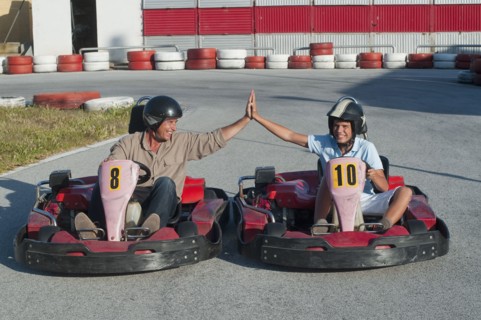 Hispanic grandfather and grandson on go-cart track