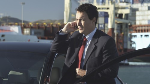 Hispanic businessman talking on cell phone on dock